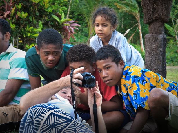 Sarah F. showing the village kids their digital photos